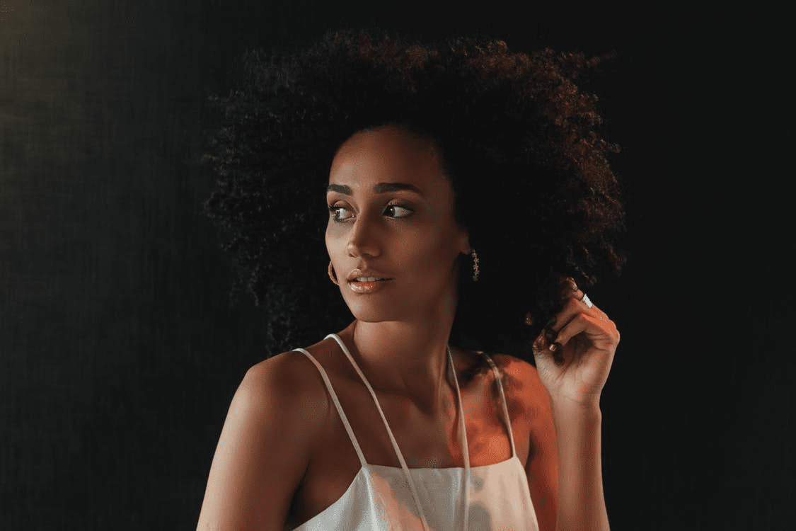 Женщина сидит в позе лотоса с закрытыми глазами и легкой улыбкой