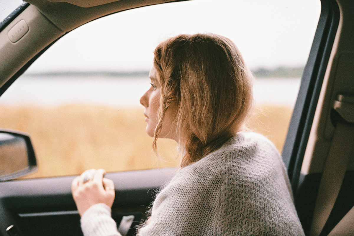 Женщина улыбается, держа в руках награду или диплом