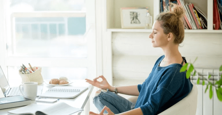 Женщина работает за столом с ноутбуком и блокнотом, эффективно планируя свое время